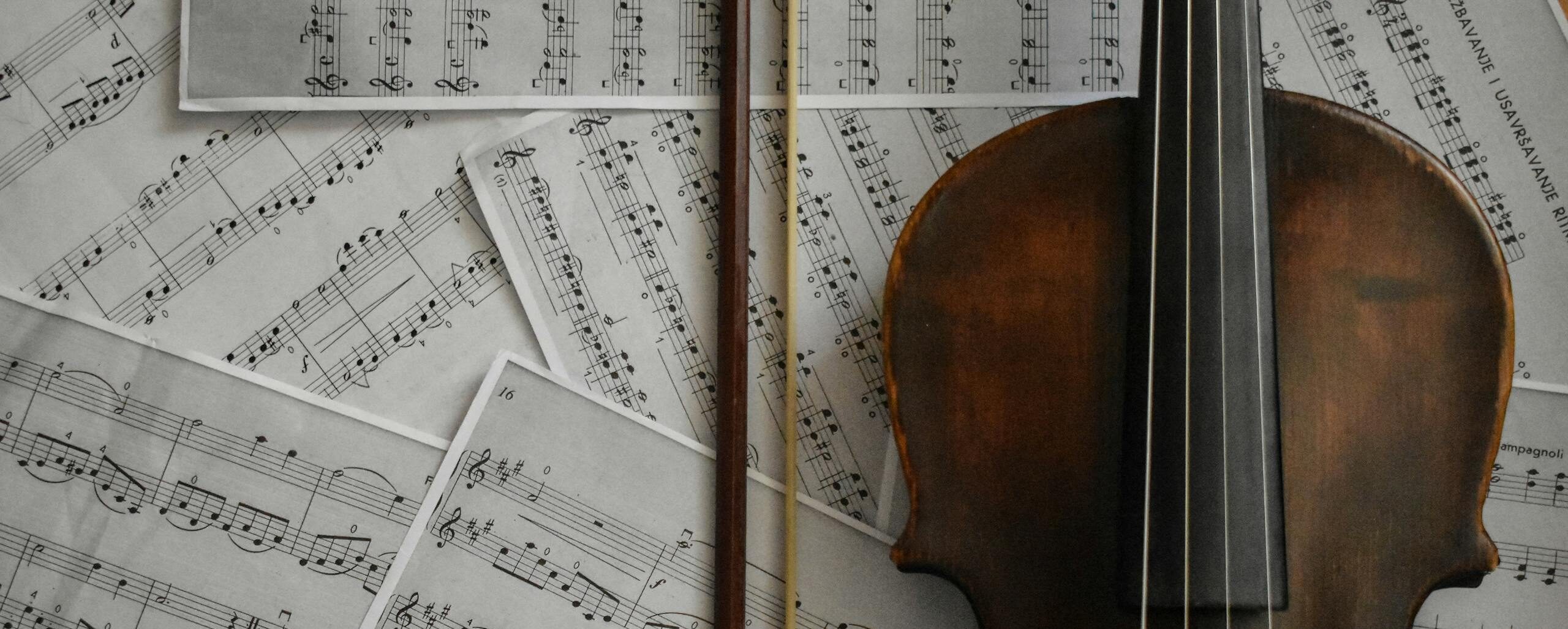 A detailed view of a violin resting on musical sheets, capturing an artistic arrangement.